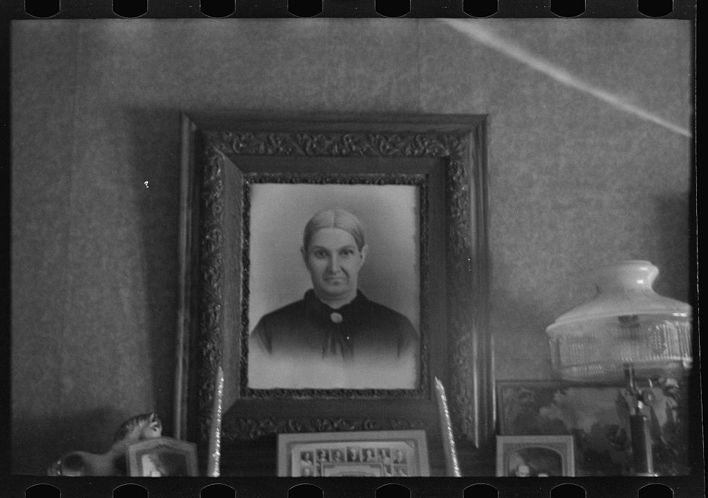 A framed portrait of an elderly woman on the mantel of an Iowa farmhouse, photographed on film in 1936.
